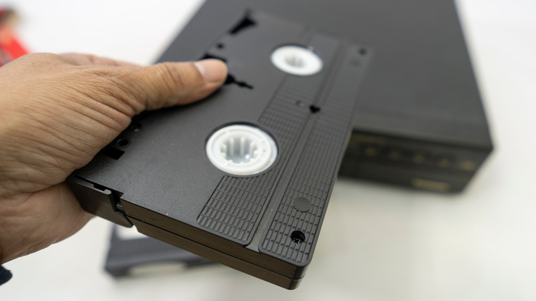 A person holding a VHS tape