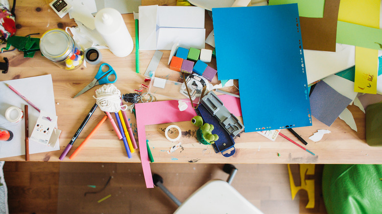 A desk cluttered with crafting supplies