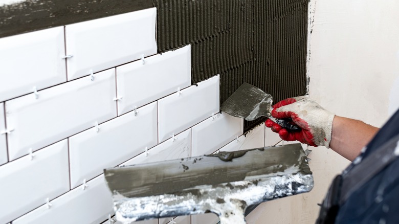 Tiles being installed on a wall 