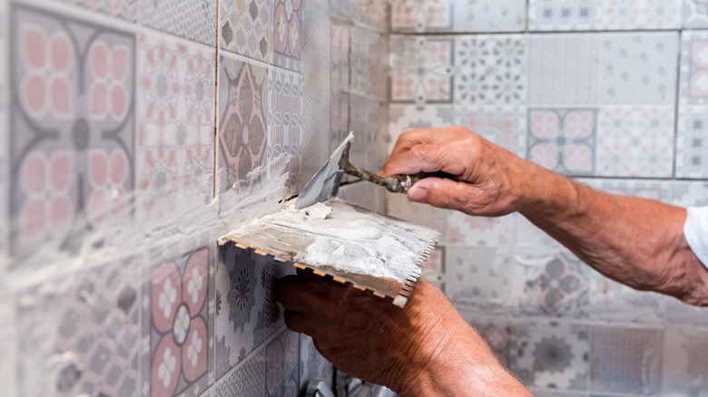 A man grouting tiles 