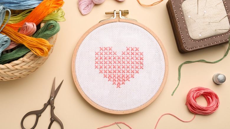 embroidery tools next to an cross-stitched heart