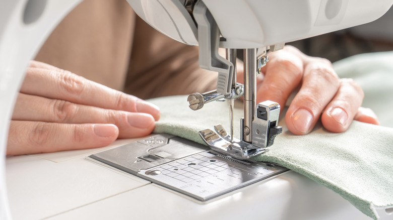 person sewing on a sewing machine