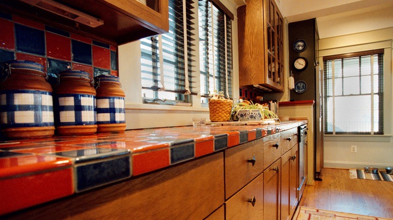 outdated kitchen with red black tile countertop