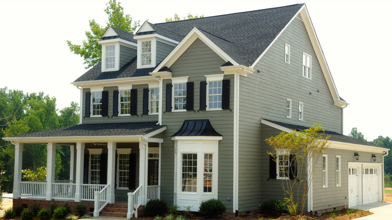 A two story home is painted sage green