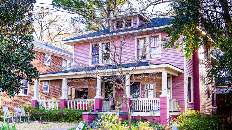 A two story house is painted bright pink