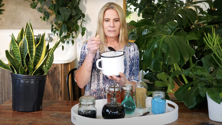 woman preparing fertilizer from glass jars