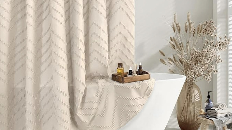 Beige shower curtain in light gray bathroom