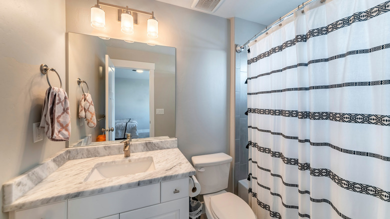 Bathroom with gray walls and striped shower curtain