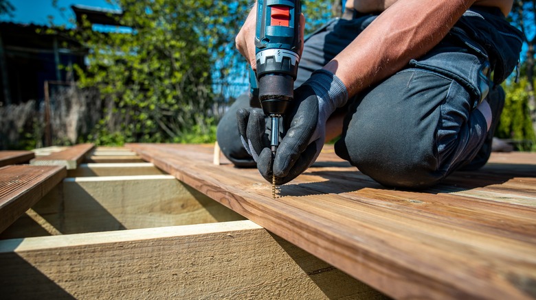 man constructing wood deck