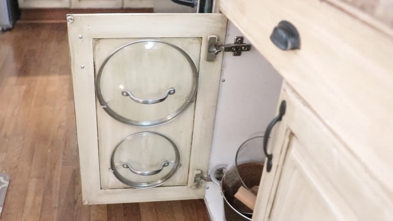 two pot lids hanging cabinet door