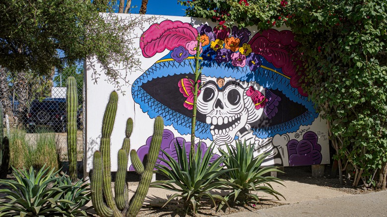 Colorful painted mural on white wall of skeleton