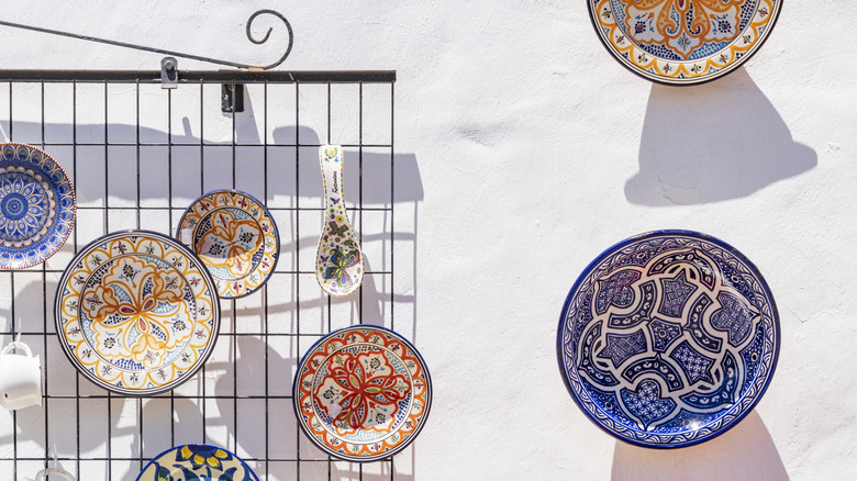 Colorful patterned plates hanging on white exterior wall