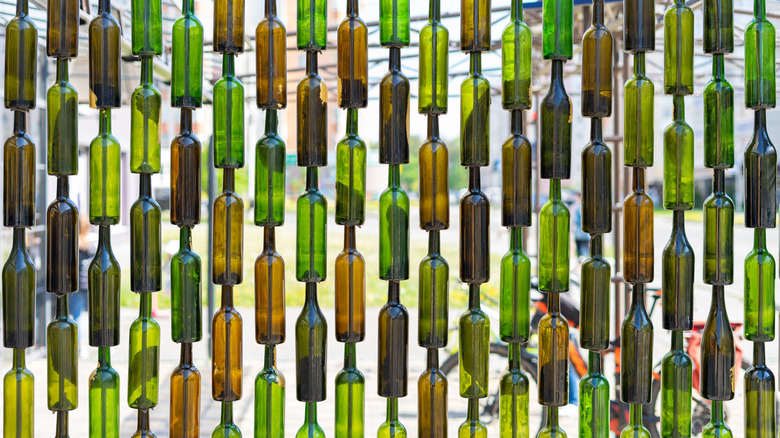 Green and brown bottles forming an outdoor wall