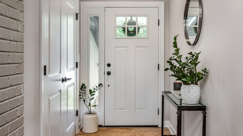 A glass and metal console table inside the entryway