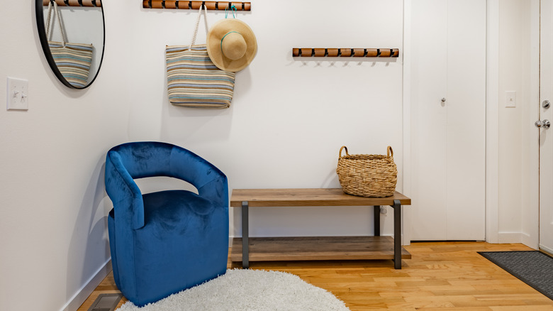 Blue velvet armchair in the corner of an entryway