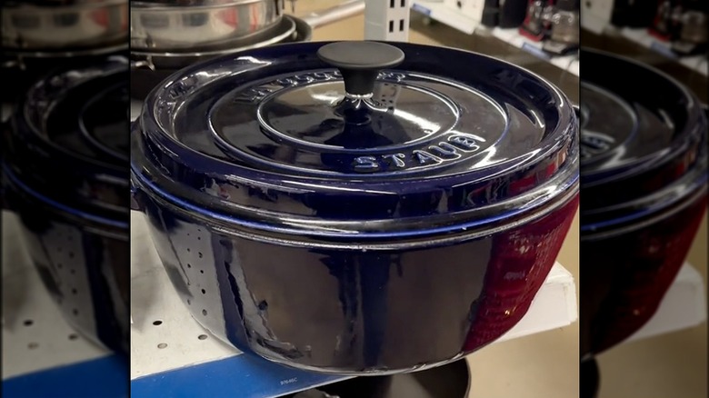 Dark blue Staub Dutch oven on a shelf at a thrift store