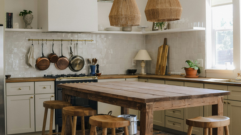 A rustic kitchen with a wooden table in the center