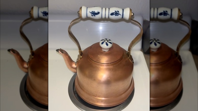 Copper kettle sitting on a stove