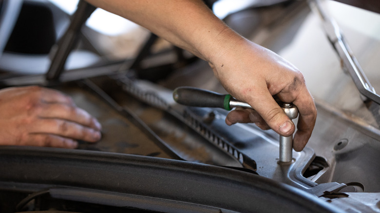 A hand using a socket wrench.