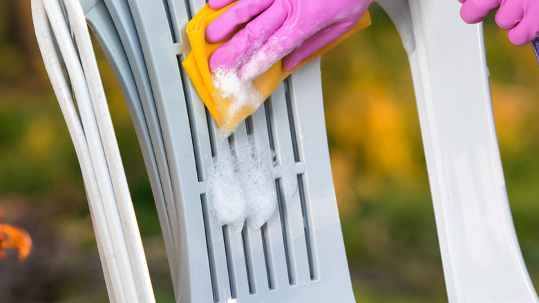 Person scrubbing outdoor chair