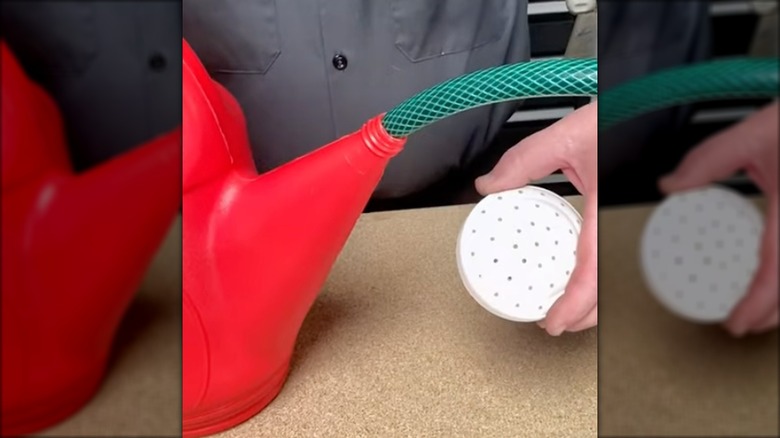 Person placing a garden hose into a watering can nozzle as an extension