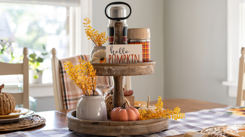 Tiered tray on table filled with small fall decorations