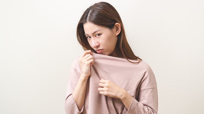 Woman smelling her shirt