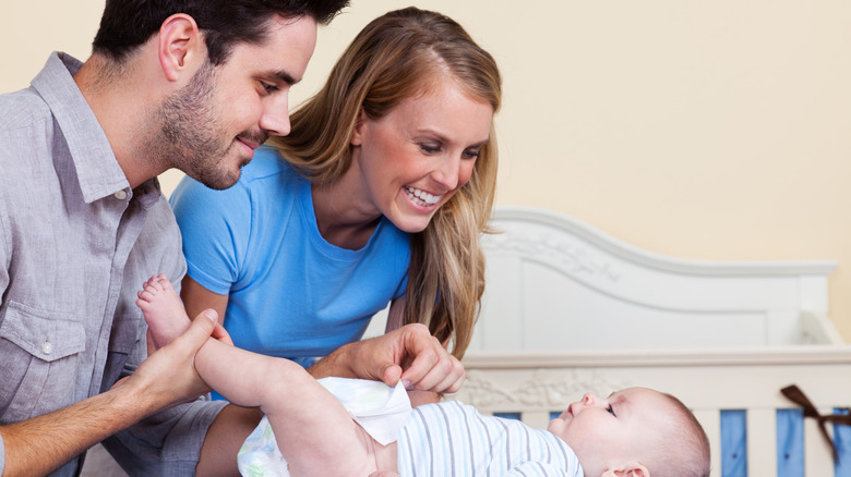 Parents changing a baby's diaper