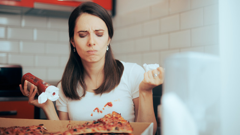 Woman lamenting her pizza-stained shirt