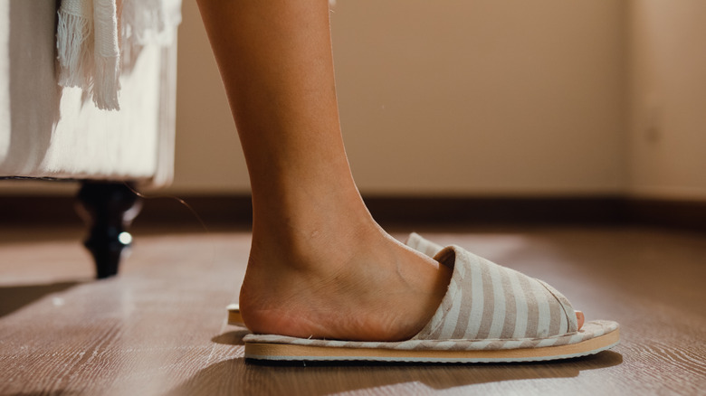 Feet in striped slippers on wood floors