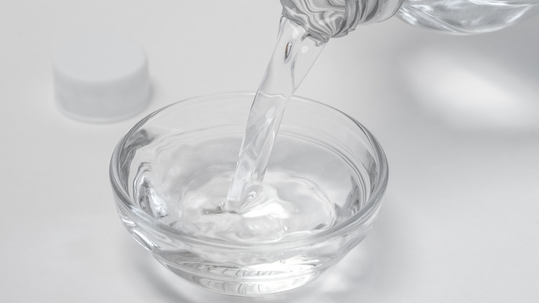 Pouring white vinegar into a bowl