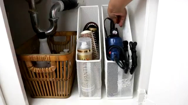 Hair curter, hair dryer, and styling products stored in a file holder