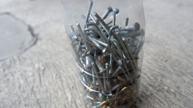 Stacks of nails clustered together inside a plastic bottle