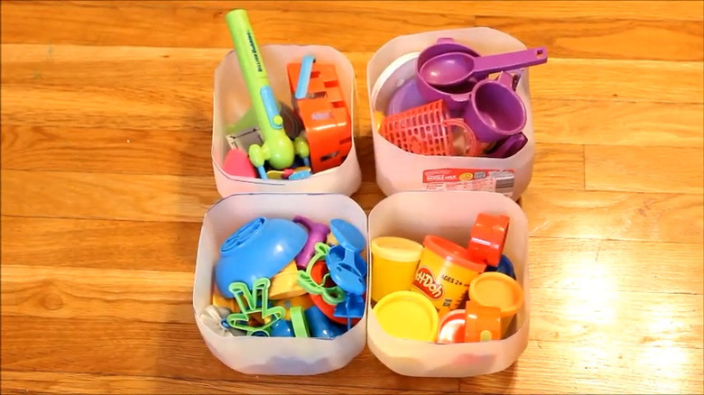 Four milk jugs repurposed into toy storage