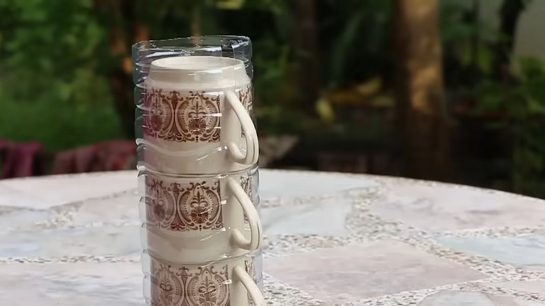 Set of stacked mugs inside of a plastic bottle