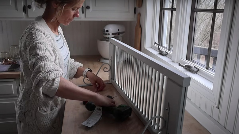 Someone building a shelf with a shutter to hold China dishes.