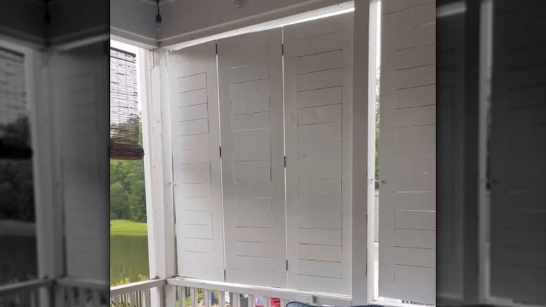 Trifold white shutters are extended to add privacy to a covered porch.