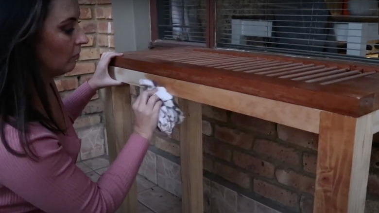 Someone creating a DIY table with an old shutter