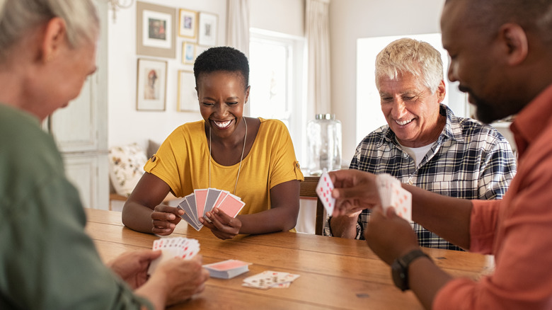 Group of people play a game of cards at a table