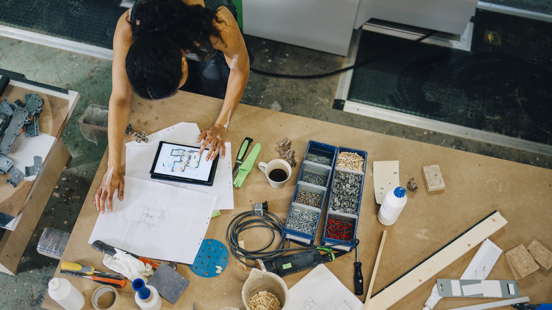 Woman planning out a woodworking project on a table