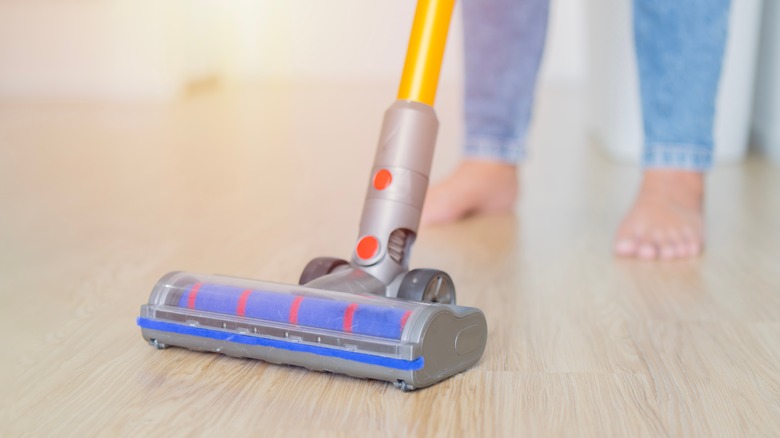 woman vacuuming wooden floors