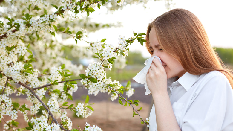 woman smelling a flower outside