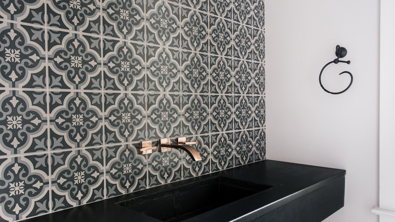 Backsplash with floral tile in black and white behind sink