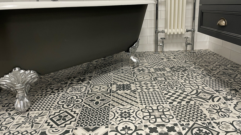 Black and white patchwork tile in bathroom underneath bathtub