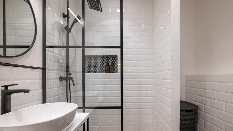 Black penny tiles in alcove with white subway tiles in shower