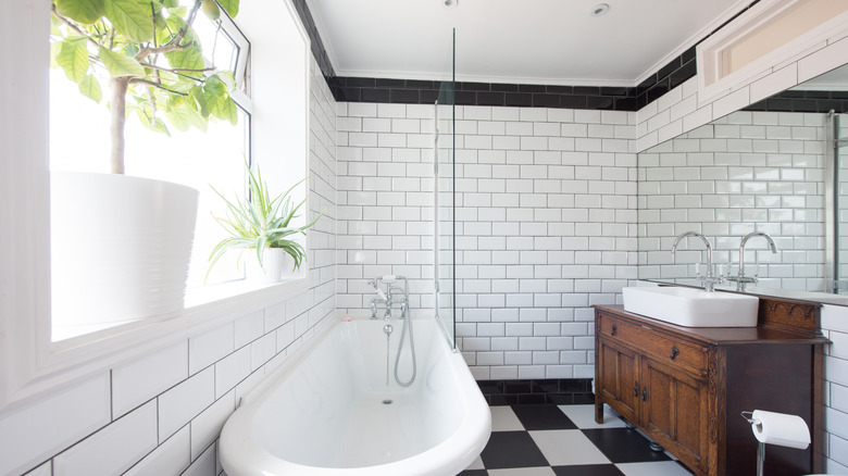 White subway tiles with black line near ceiling and checkerboard floor