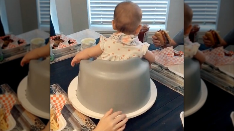 A baby in a chair on top of a lazy Susan