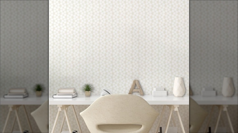 Dotted neutral wallpaper behind desk