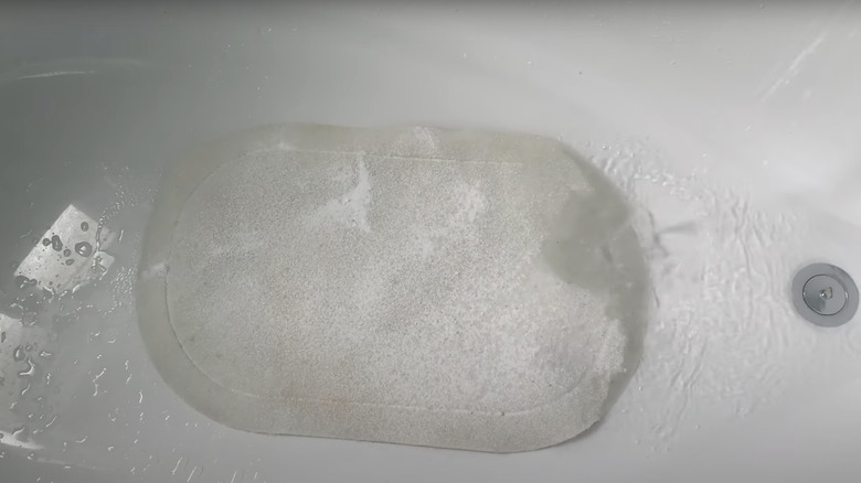 white bath mat soaking in tub