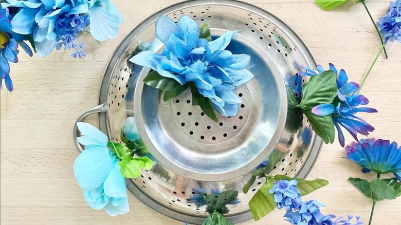 blue faux flowers in colander